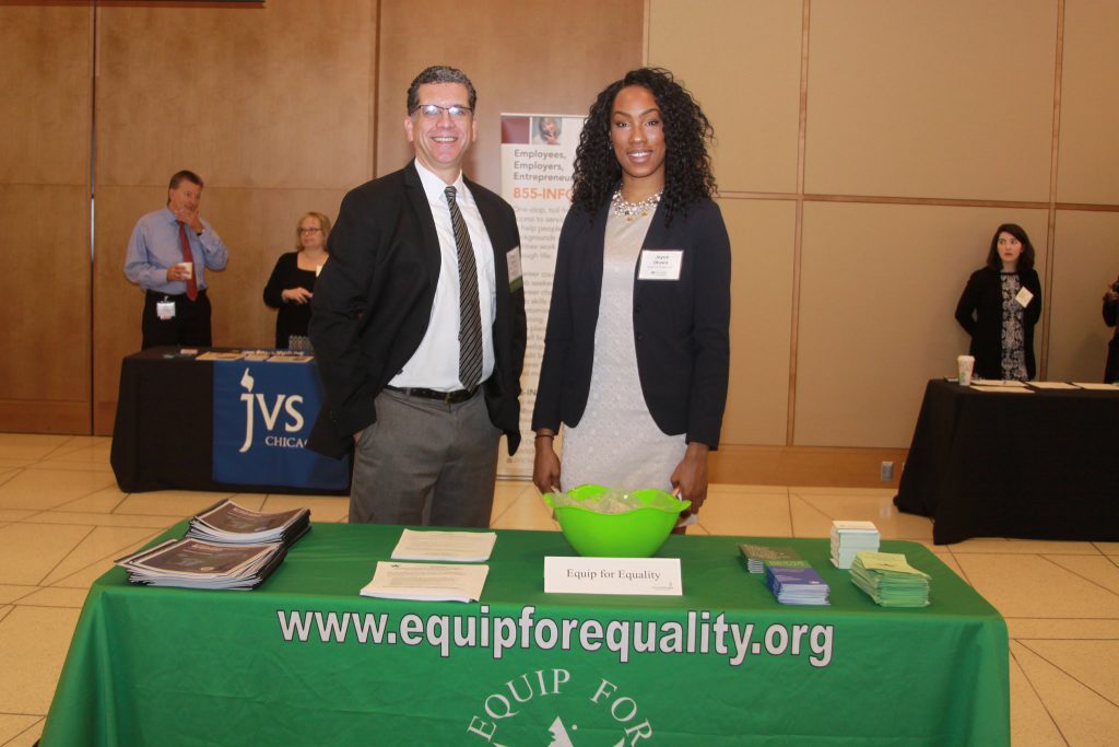 Barry Taylor and Joye Otuwa stand at the Equip for Equality exhibitor table at the Disabliity Inclusion Opportunity Summit